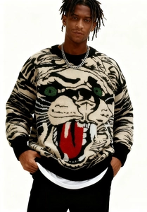 Détails de la maille jacquard du pull tête de tigre avec yeux verts et langue rouge vif