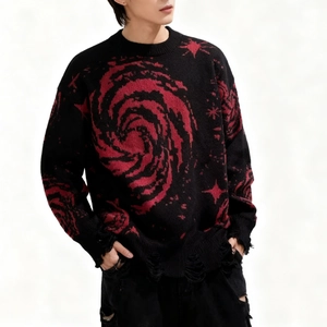 Close-up of distressed hem with frayed fringe and cosmic star jacquard on a black sweater