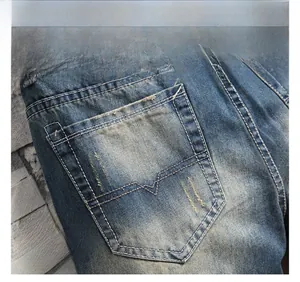 Detailed close-up of rear pocket on vintage washed blue jeans with distressed edges