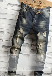 Détail d'un jean vintage délavé avec moustaches de chat et déchirures aux genoux