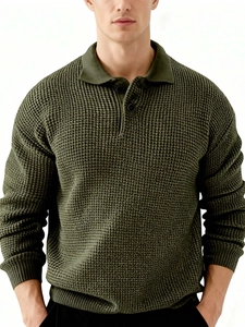 Close-up of olive green waffle knit texture and ribbed collar on men's polo sweater