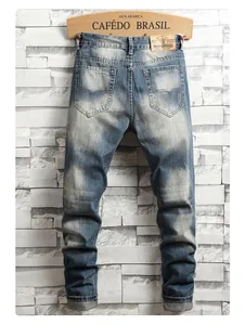 Detail showing distressed blue denim jeans with back pockets and leather waist tag
