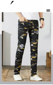 Detail view of American high street style printed denim jeans with yellow artistic patterns