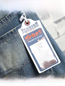 Detail view of denim jeans fabric label and ripped texture in dark blue washed style
