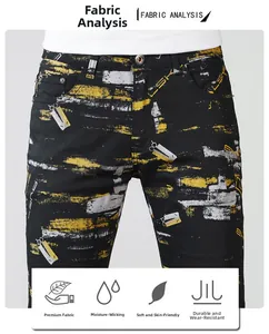 Detail of moisture-wicking black denim pants with yellow and white graffiti print