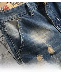 Detail of distressed blue jeans with washed effect, reinforced rivets and star pattern lining