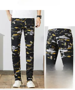 Detail view showing street-style graffiti print on slim-fit black denim trousers