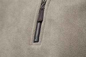 Détail du tissu polaire avec fermeture éclair métallique et tirette en cuir premium