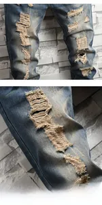 Close-up of distressed denim texture with ripped knee detail and vintage washed fabric