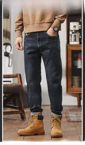 Detail of dark blue vintage straight-leg denim jeans with retro washed finish and stitching