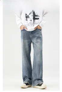 Detail view of baggy straight-leg jeans with vintage washed light blue denim finish