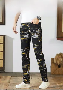 Detailed close-up of urban street style jeans with abstract yellow and white paint splashes