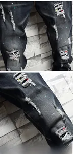 Detail der dunkelgrauen Jeans mit Distressed-Patchwork und neonfarbenen Farbspritzern