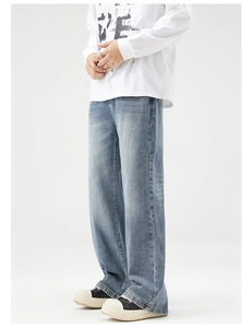 Detail of light blue wide-leg jeans featuring a vintage wash and draped denim texture