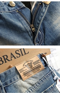Close-up of vintage washed denim with bronze buttons and branded leather waist patch