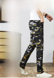 Detail of slim-fit jeans with yellow paint splatter and graffiti print for men