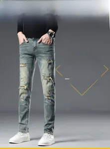 Détails d'un jean slim délavé avec moustaches et finitions usées sur tissu en denim