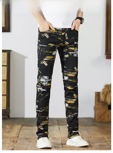 Detail of slim fit black denim jeans with yellow and white paint splatter print pattern