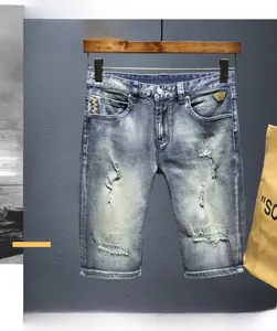 Dettaglio dei pantaloncini di jeans celeste lavati con effetti usurati e motivi a baffo di gatto
