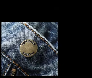 Detail of vintage copper heritage palmer button and yellow stitching on blue denim jeans