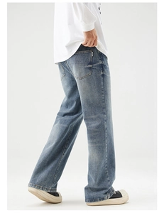 Detailed side-back view of vintage washed denim jeans with a wide-leg loose fit and metal tag