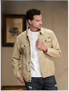 Detail shot of khaki denim jacket featuring classic collar and black logo on breast pocket