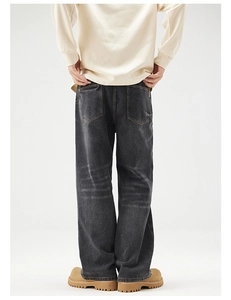 Detailansicht der Rückseite einer gewaschenen schwarzen Wide-Leg-Jeans mit Used-Effekt