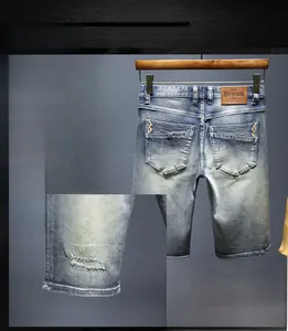 Dettaglio di pantaloncini di denim lavato con effetto consumato e orlo sfilacciato