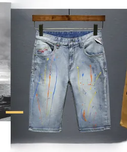 Detail of colorful paint splatter and red embroidery on vintage blue denim shorts