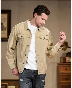 Detail of khaki denim jacket featuring flap chest pockets and metallic buttons for men