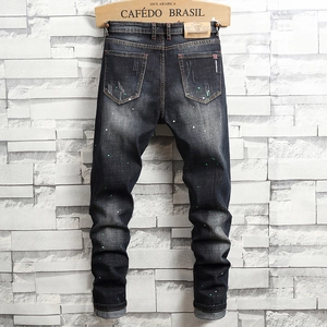 Schmal geschnittene Herrenjeans in Dunkelblau mit Farbspritzern und Vintage-Waschung