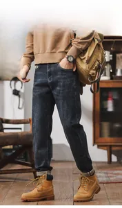 Detailed view of dark blue washed denim fabric with retro faded texture on slim fit jeans