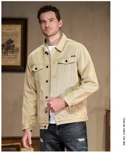 Detail of khaki denim jacket featuring flap pockets with JEANS woven label and twill texture