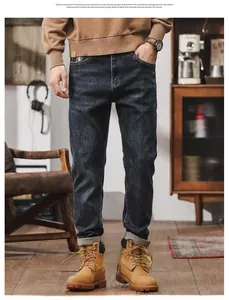 Close-up of men's dark blue straight-leg jeans styled with vintage boots and retro decor