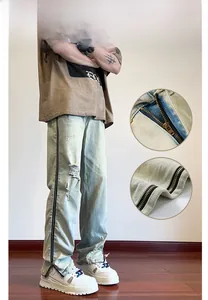 Detail of light blue washed jeans with side zipper design and frayed hem craftsmanship