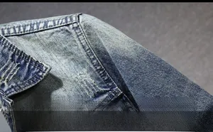 Detailed macro view of retro washed blue denim jacket shoulder with distressed vintage textures
