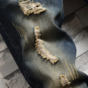 Jean bleu vintage délavé avec détails usés et déchirures de style streetwear