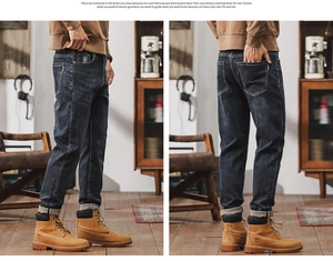 Detail view of dark blue washed denim jeans with turn-up hem and vintage aesthetic style