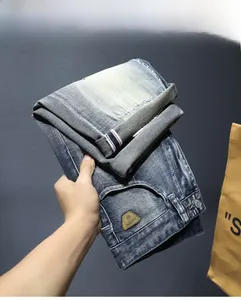 Dettaglio ravvicinato di pantaloncini di jeans blu lavati con finitura vintage e targhetta in pelle