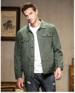 Detail of army green denim jacket with double chest pockets and metallic buttons