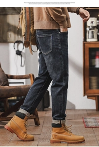 Detail of dark blue straight-leg jeans with vintage wash and reinforced stitching