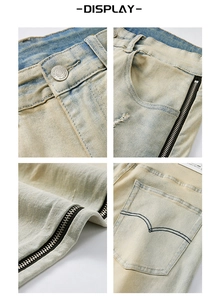 Detail view of retro blue denim jeans with metal zipper, decorative stitching and washed texture