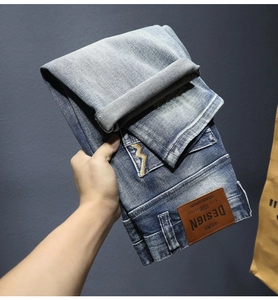 Dettaglio dei pantaloncini in denim blu vintage con patch in pelle e ricamo a saetta