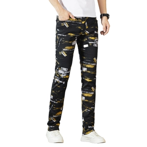 Men's slim fit casual trousers in black featuring vibrant yellow paint splatter print