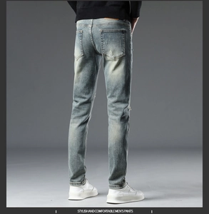 Jean slim bleu pour homme avec délavage vintage et patch en cuir orange à la taille