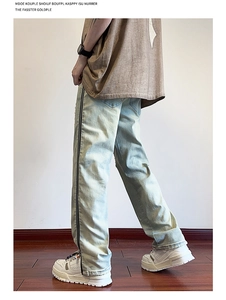 Detail view of American vintage light blue jeans featuring a side zipper design and distressed hem