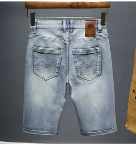 Detailed back view of vintage light blue denim shorts featuring stitched M pattern pockets