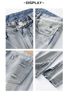Dettaglio di jeans blu consumati con cerniere metalliche e texture strappate