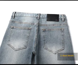 Detail view of denim jeans back featuring high-quality leather logo patch and double pockets
