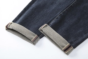 Detail shot of denim cuff with tricolor decorative stitching and light grey inner lining